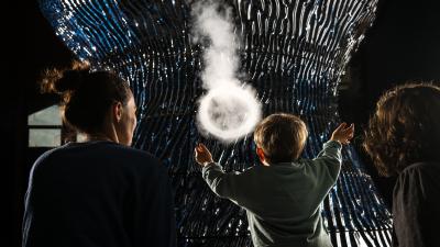 Child interacting with a sculpture at Eden